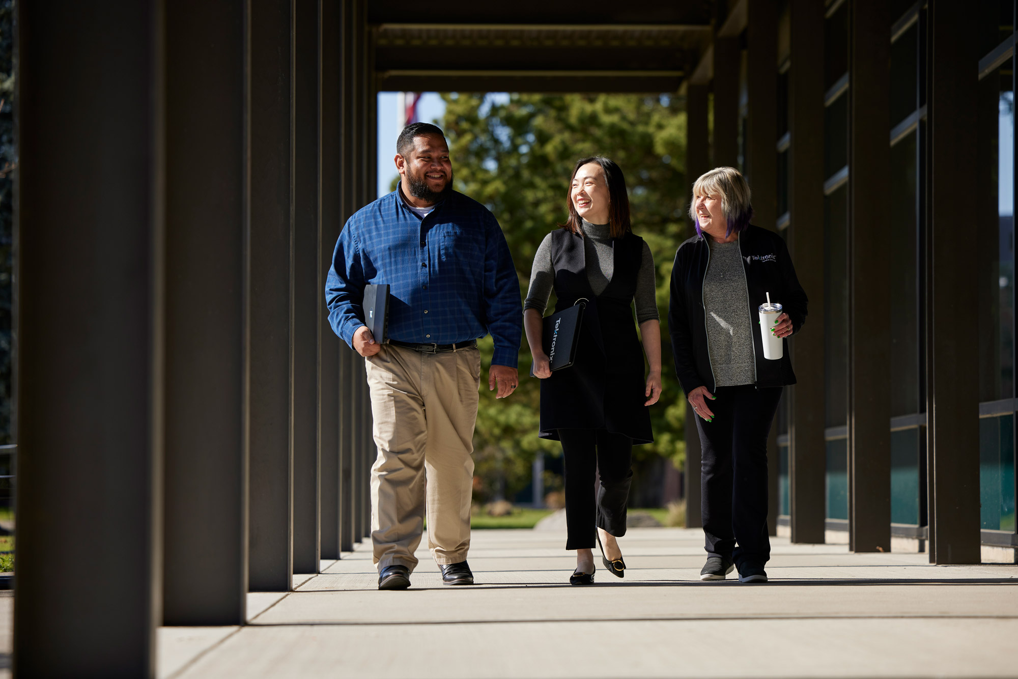 Trio of employees walking and smiling