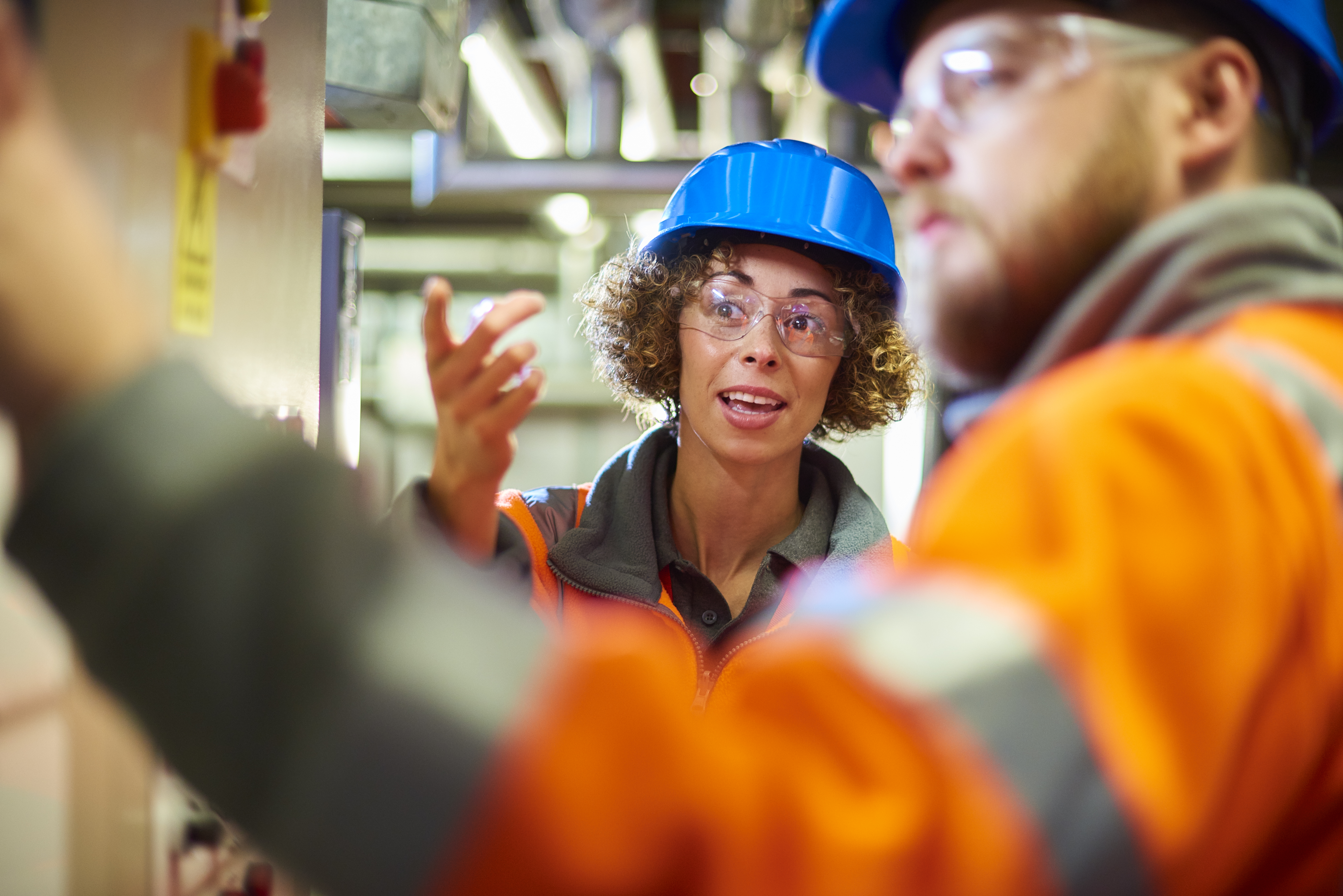 Male and female engineer in hard hats working together to solve a problem